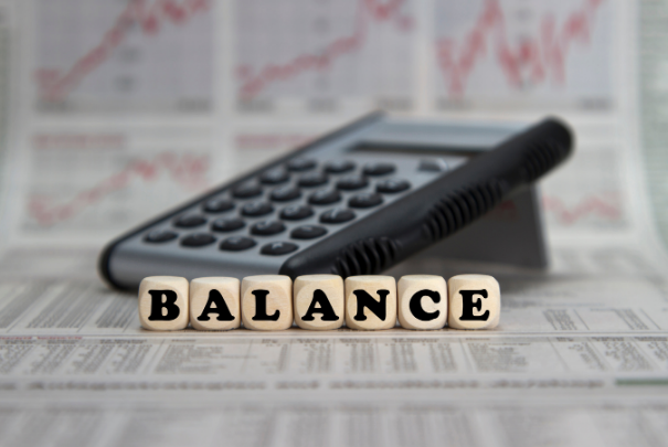 Balance als Ziel in der Entwicklung der neuen Anwendung - hier dargestellt anhand eines Bildes von einem Taschenrechner und dem Wort Balance davor.