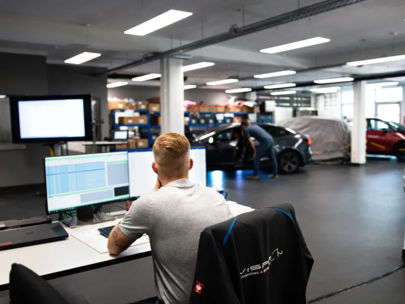 Vispiron Mitarbeiter sitzt im V-Lab am Computer und analysiert Fahrzeugdaten